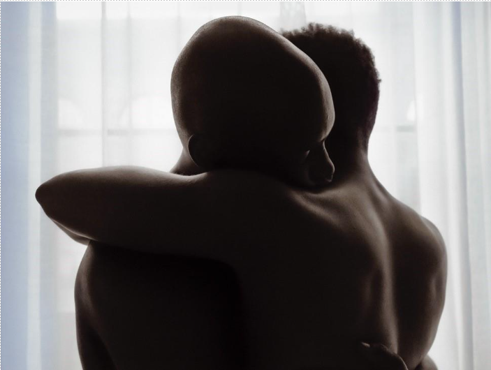two nude individuals embracing